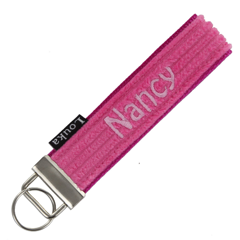 Handgemaakte Louka pols sleutelhanger van brede rib in zacht roze, personaliseerbaar met naam en hardware, formaat 13×3 cm.